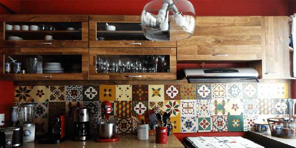 o ladrilho hidráulico é colorido e, por isso, ganha destaque quando combinado aos armários de cozinha em madeira