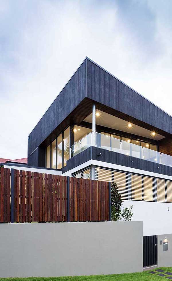 casa luxuosa muro alvenaria cimento Casa luxuosa combinando um muro baixo em alvenaria com a parte de cima em tábuas de madeira