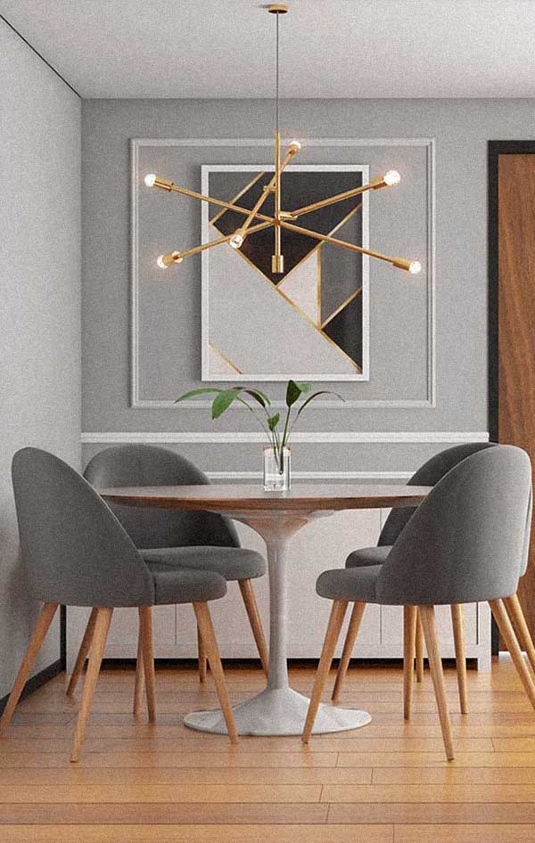 A moldura boiserie destacou o quadro geométrico, que traz cores que combinam com toda a sala de jantar