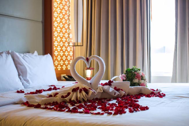 Lua de Mel 0 Decoração de cama com pétalas de rosas.