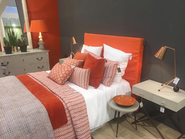 almofadas coloridas na cama 6 Almofadas laranjas com lençol branco.
