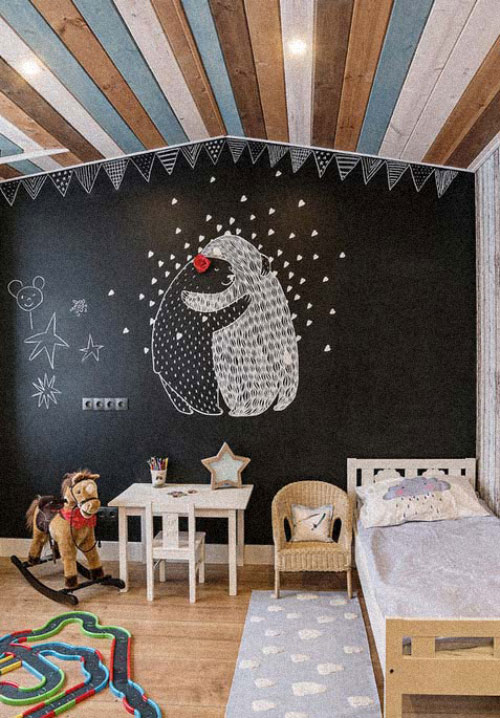 parede lousa infantil A parede de lousa fica perfeita para um quarto de menino rústico. Nesse, destaca-se o teto de ripas de madeira coloridas